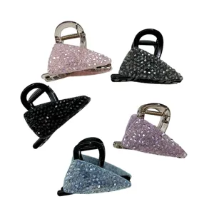 Close-up view of five sparkling crystal-encrusted hair claw clips in various colors