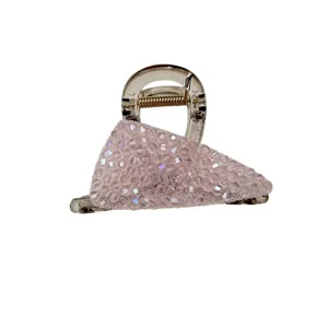 Detailed view of a light pink crystal rhinestone hair claw clip on white background