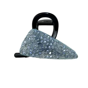 Close-up of light blue crystal-studded triangular hair claw clip with black base