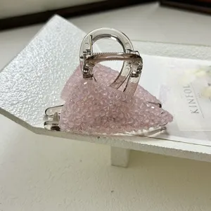 Detail shot of elegant pink crystal beaded triangular hair claw clip for women.