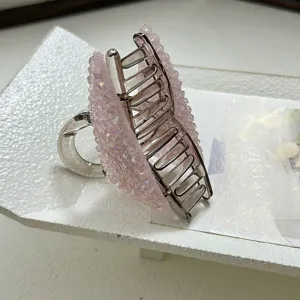 Detailed close-up of elegant hair claw clip with shimmering pink crystal butterfly design