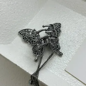 Detailed view of a gunmetal butterfly hair claw clip with elegant chain tassels