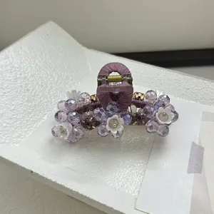 Détail rapproché de la pince à cheveux à perles violettes et fleurs de cloche