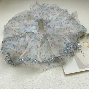 Primo piano di elastico in organza floreale con eleganti perline di cristallo blu