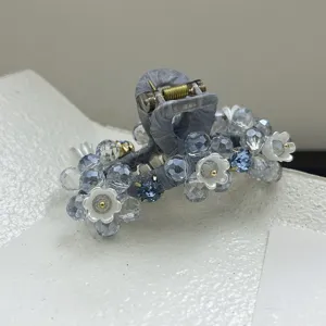 Vue rapprochée d'une pince à cheveux élégante avec fleurs bleues et perles cristal
