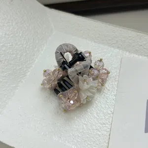 Vue macro de la pince à cheveux style fée avec perles roses et détail de fleur blanche