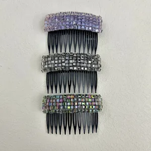 Close-up of three crystal-studded non-slip hair insert combs in purple, grey, and iridescent.