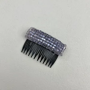 Detailed top view of a sparkling purple crystal hair side comb with black plastic teeth.