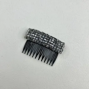 Detail of smokey grey crystal hair comb with non-slip black teeth for styling.