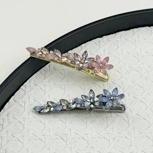Macro detail of elegant handmade crystal flower duckbill hair clips in pink and blue