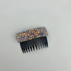 Close-up of iridescent rectangular crystals on a black multi-tooth hair insert comb