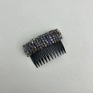 Detail view of iridescent purple and grey crystal beads on a black toothed hair comb
