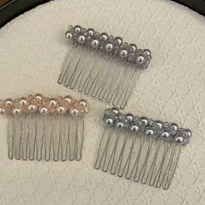 Vue détaillée de trois élégants peignes à cheveux en perles sur fond blanc tissé