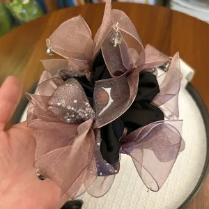 Gros plan d'un chouchou noeud mauve élégant avec cristaux et perles scintillants
