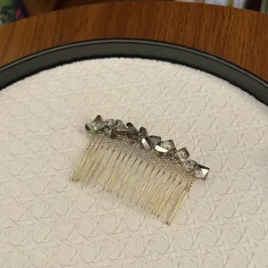 Detailed view of elegant gold-toned insert hair comb featuring faceted grey crystals.