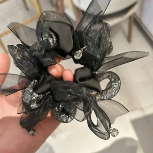 Gros plan d'un chouchou en organza noir élégant avec des strass et des perles de cristal