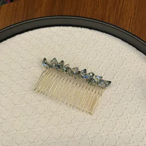 Detailed macro view of iridescent crystal stones on a gold-toned metal hair insert comb