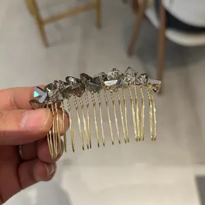 Detailed macro view of elegant gold-toned hair comb featuring dark faceted crystals