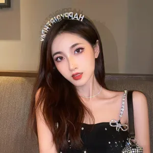 Primo piano di un elegante cerchietto HAPPY BIRTHDAY con strass indossato da una modella