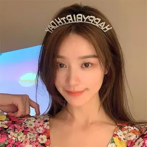 Primo piano di un cerchietto con strass Happy Birthday argento indossato da una modella