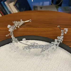 Elegant silver bridal headpiece featuring intricate leaf motifs and sparkling crystals