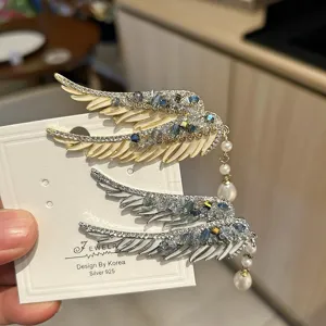 Luxury angel wing hair clip featuring crystals and pearl tassels in gold and silver finish