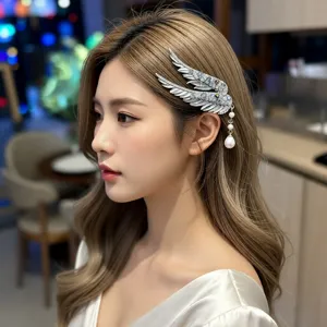 Detailed view of angel wing hair clip with crystals and pearl tassel on model's hair