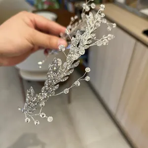 Close-up detail of a silver bridal hair chain with crystal leaf and bead accents.
