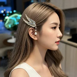 Detailed view of a luxury angel wing hair clip with crystals and a pearl tassel on a model.