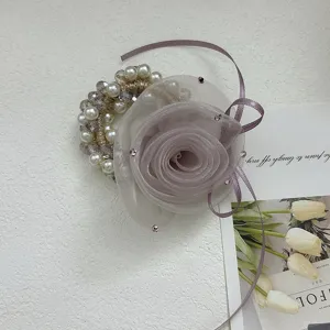 Détail d'un chouchou rose en organza violet avec perles et cristaux