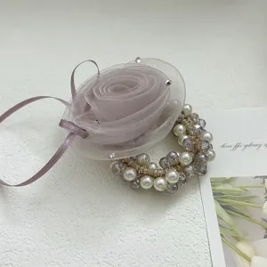 Détail élégant d'un élastique à fleurs en maille rose avec perles et cristaux facettés