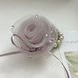 Gros plan d'un élégant chouchou rose en maille mauve avec strass et ruban.