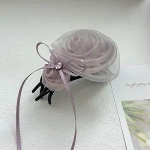 Vue détaillée d'une élégante pince à cheveux rose en tulle lavande avec un nœud ruban