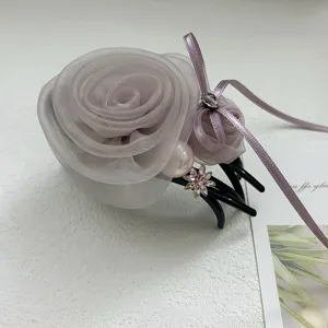 Détail d'une élégante pince à cheveux en rose résille avec perle et cristal