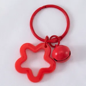 Levendige rode legering sleutelhanger met ster en bel op een witte achtergrond.