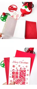 Detalle de tarjeta navideña calada con sobre rojo y hoja interior blanca de papel