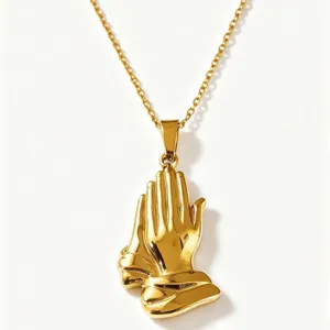 Gold stainless steel praying hands pendant necklace detail, trendy vintage fashion jewelry accessory.