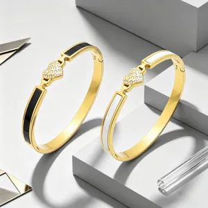 Bracelets joncs tendance en acier titane dore coeur strass, incrustes noir et blanc elegantes.