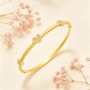 Detail de gros plan d'un bracelet jonc dore orne d'un magnifique coeur scintillant.