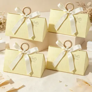 Close-up of four elegant triangular gift boxes with wooden ring handles and bows