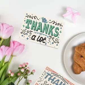 Primer plano de una tarjeta 'THANKS a lot' dibujada a mano con tulipanes y cruasán