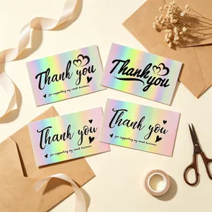 Detailed macro shot of holographic rainbow thank you cards with various elegant fonts