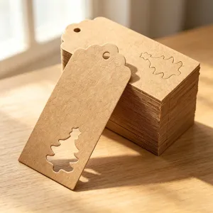 Close-up of kraft paper gift tags with a hollow Christmas tree design on wood.