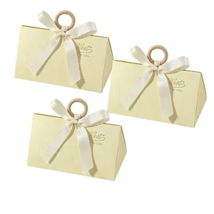 Elegant triangular wedding favor boxes with wooden ring and cream ribbon detail