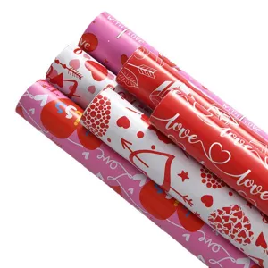 Detailansicht von Valentinstag-Geschenkpapierrollen mit Herz- und Liebestextmustern.