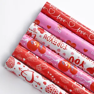 Nahaufnahme verschiedener Rollen Valentinstag-Geschenkpapier mit Herzmotiven und Text.