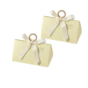 Close-up of elegant triangular wedding gift box with wooden ring and ribbon bow