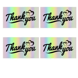 Detailed macro view of holographic rainbow thank you cards with black cursive text