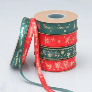 Primer plano de cintas navideñas con lámina dorada y motivos de Feliz Navidad y copos de nieve.