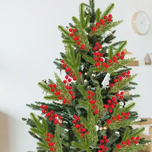 Decorative artificial red berry stems nestled within green pine needles of a Christmas tree